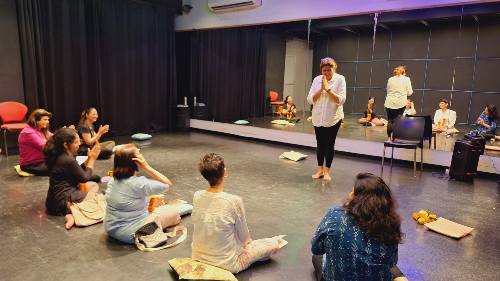 Meditation workshop with participants wearing flower garlands